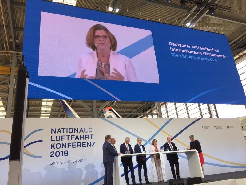 Senatorin Kristina Vogt spricht auf dem Podium der Nationalen Luftfahrtkonferenz 2019 Senatorin Kristina Vogt spricht auf dem Podium der Nationalen Luftfahrtkonferenz 2019