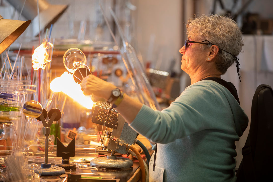 Die Flamme im Gasbrenner ist knapp 2000 Grad heiß, im Sommer kann das sehr anstrengend werden. Glasbläserin Irene Borgardt fertigt in ihrer Werkstatt Wein-, Sekt- oder Grappagläser, von denen keins dem anderen gleicht.