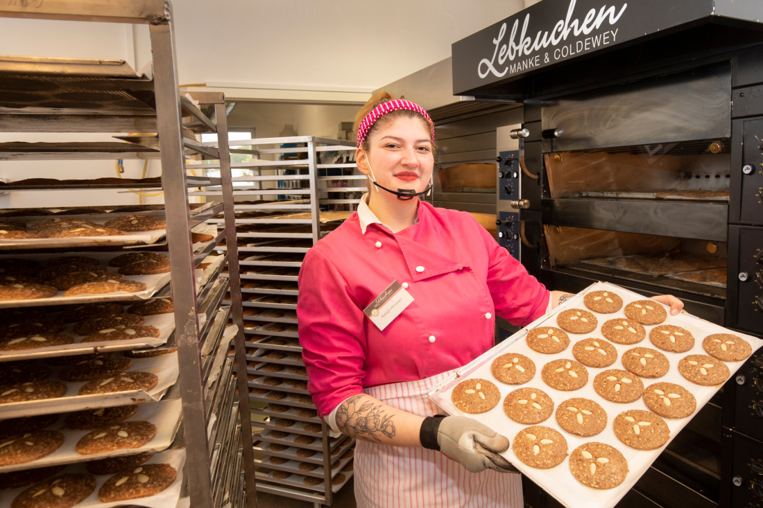 Mitarbeiterin Aysegül Almaoglu präsentiert ein Blech mit Lebkuchen. 