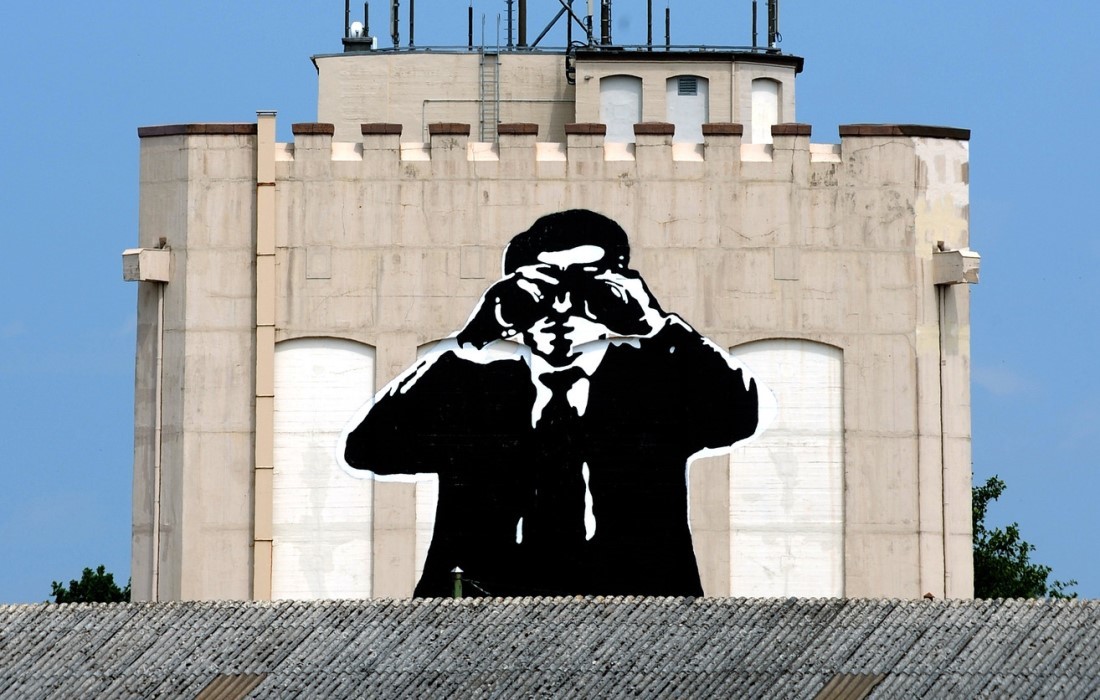 Graffiti auf einem Bremer Bunker: Ein Mann im Anzug blickt durch ein Fernglas.