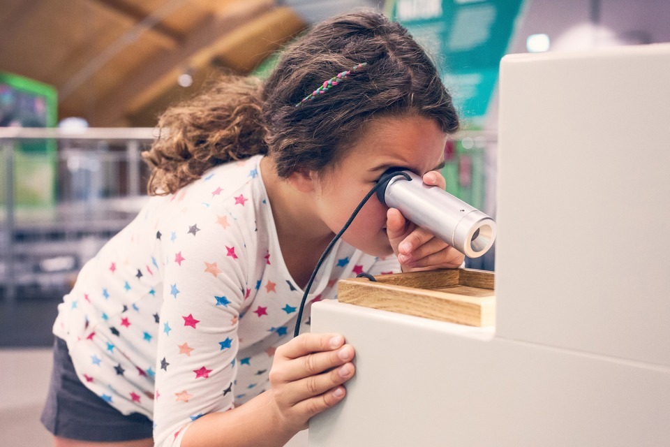 Girl looking through a microscope