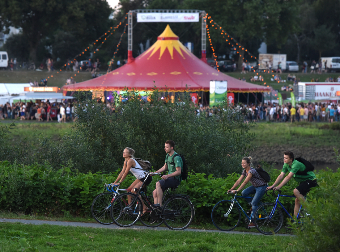 Fahrradfahrer:innen vor einem Zelt