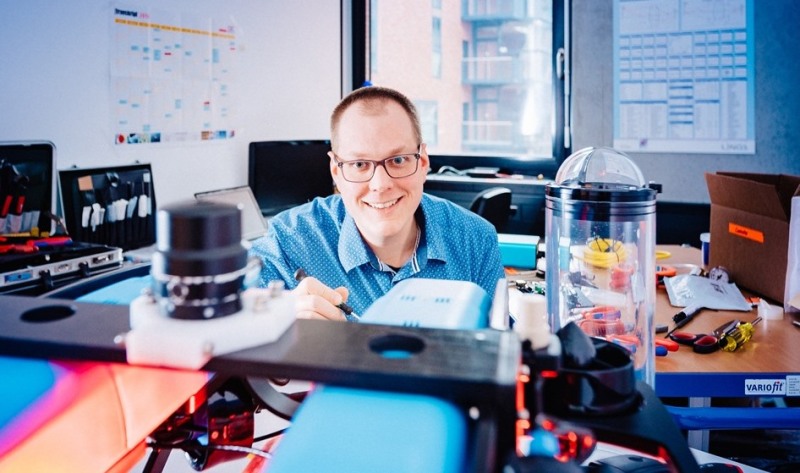 Wissenschaftler Jan Boelmann vom Labor für Meerestechnik der Hochschule Bremerhaven lächelt in die Kamera. In der Hand hält er ein schmales Werkzeug, auch um ihn herum sind Zangen und andere Werkzeuge zu sehen.