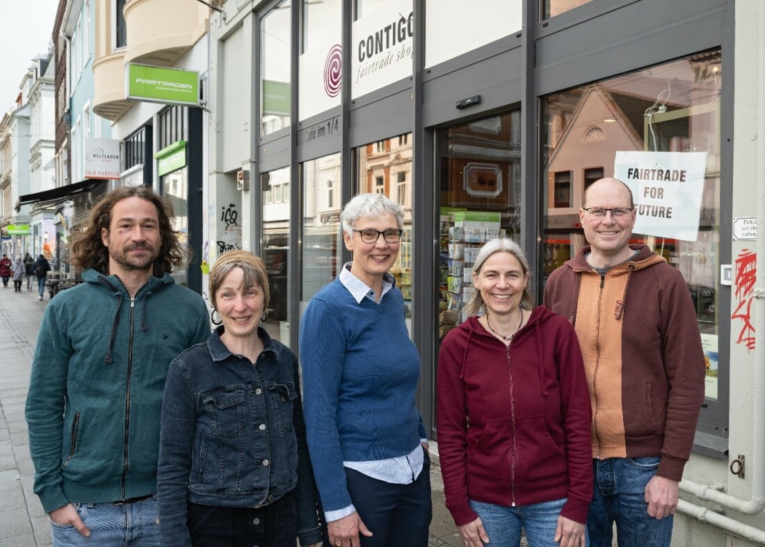 Fünf Menschen stehen vor einem Laden