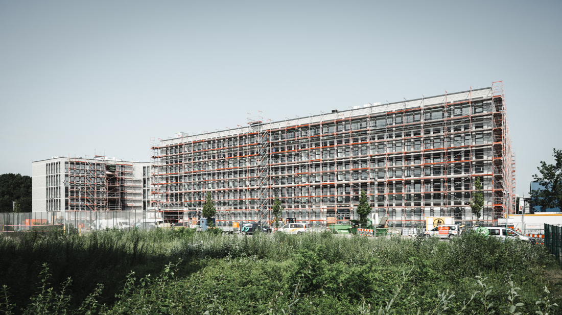 Ein großes Bürogebäude mit Baugerüsten an der Fassade. Ein großes Bürogebäude mit Baugerüsten an der Fassade.
