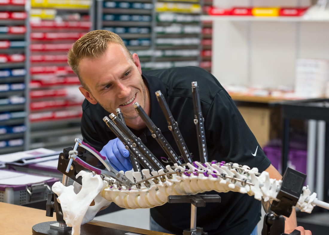 Mitarbeiter Fritjof Bassler mit dem Sawbone inklusive Wirbelsäulenimplantaten von NuVasive