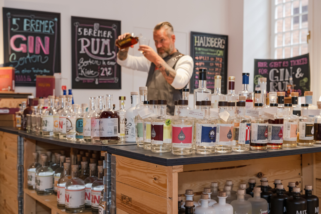 Ein Mann steht hinter einem Tresen und gießt alkoholische Getränke in ein Glas