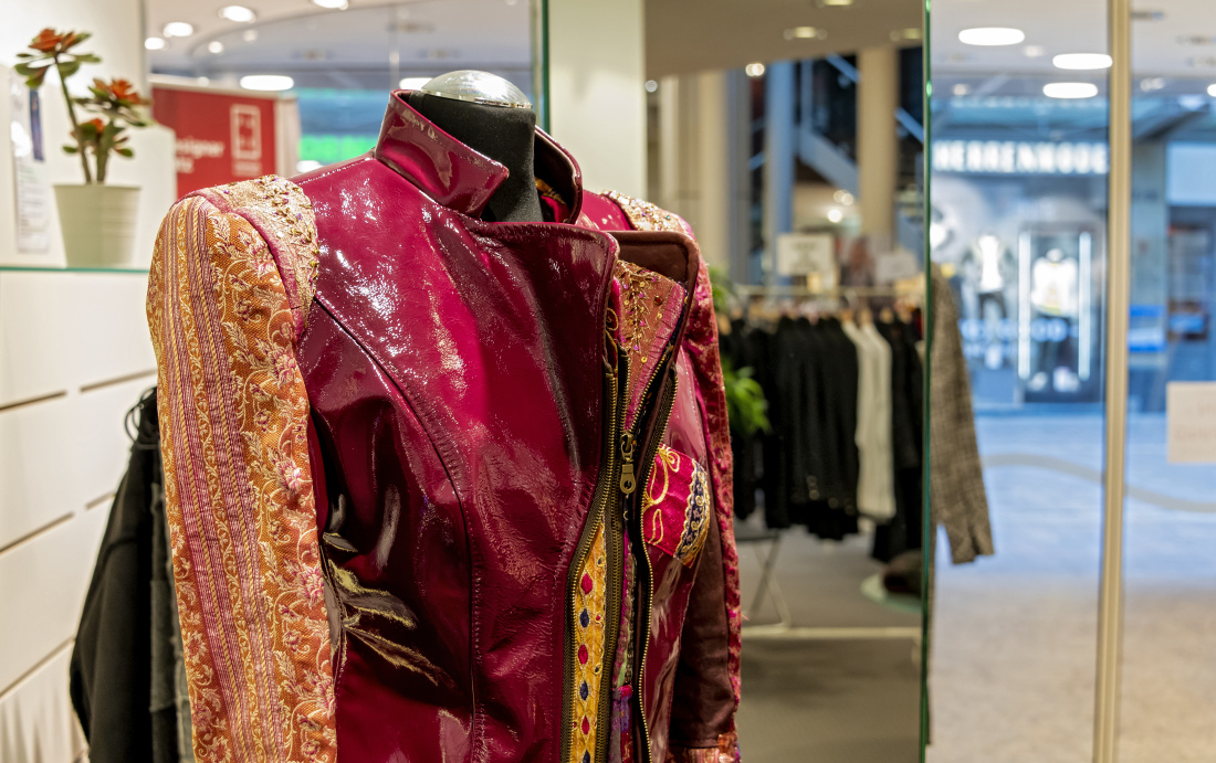 Im Stil einer Lederjacke geschnittene Jacke aus verschiedenen Stoffarten in Rot-, Gelb- und Orangetönen. Im Stil einer Lederjacke geschnittene Jacke aus verschiedenen Stoffarten in Rot-, Gelb- und Orangetönen.