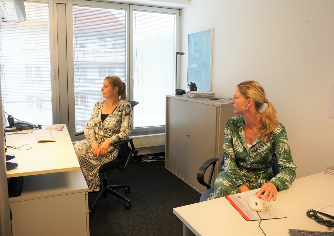 Zwei Frauen sitzen im Büro und gucken auf einen Bildschirm