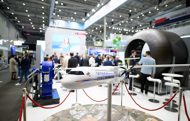 Ein Flugzeugmodell auf der Hydrogen Technology Expo 2024. Im Hintergrund sieht man den Messestand von Bremen. Ein Flugzeugmodell auf der Hydrogen Technology Expo 2024. Im Hintergrund sieht man den Messestand von Bremen.