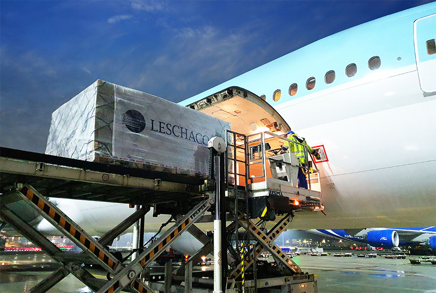 Eine große Palette mit der Aufschrift Leschaco wird auf einer Hebebühne in die Öffnung eines Frachtflugzeugs transportiert. Eine große Palette mit der Aufschrift Leschaco wird auf einer Hebebühne in die Öffnung eines Frachtflugzeugs transportiert.