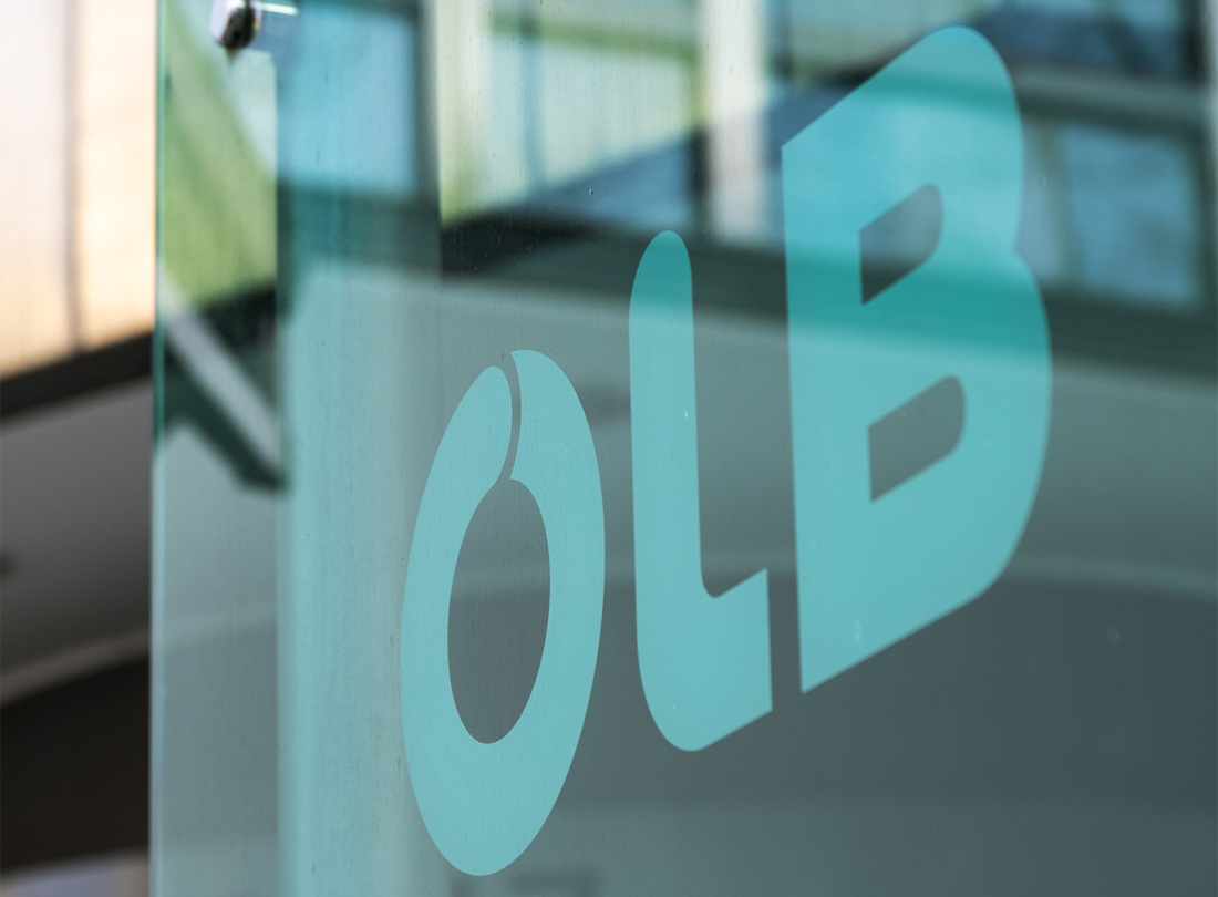 Glasschild mit dem Logo der OLB