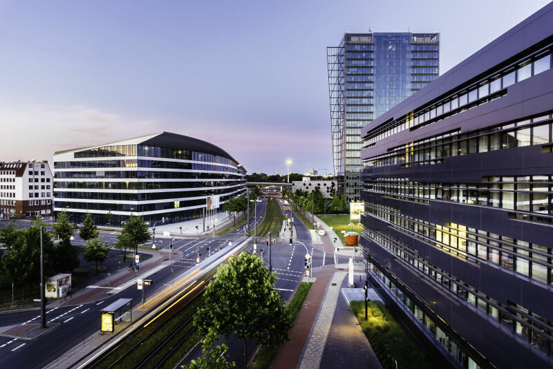 Straßenkreuzung in der Bremer Überseestadt im Abendlicht. Im Hintergrund ist der Weser-Tower zu sehen. 