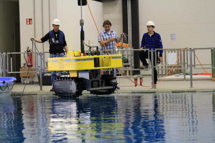 AWI-Wissenschaftler lassen den autonomen Roboter "Tramper" ins Wasserbecken.