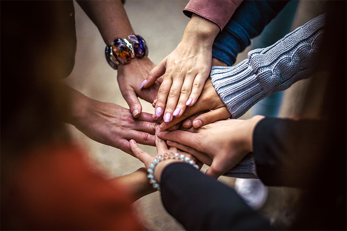 Die Hände von einer Gruppe Menschen treffen sich in der Mitte. Die Hände von einer Gruppe Menschen treffen sich in der Mitte.