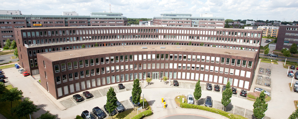 Das Gründerzentrum Airport vom Parkhaus auf der gegenüberliegenden Seite fotografiert. Man erkennt zwei in einem Halbkreis angelegte Gebäude hintereinander.