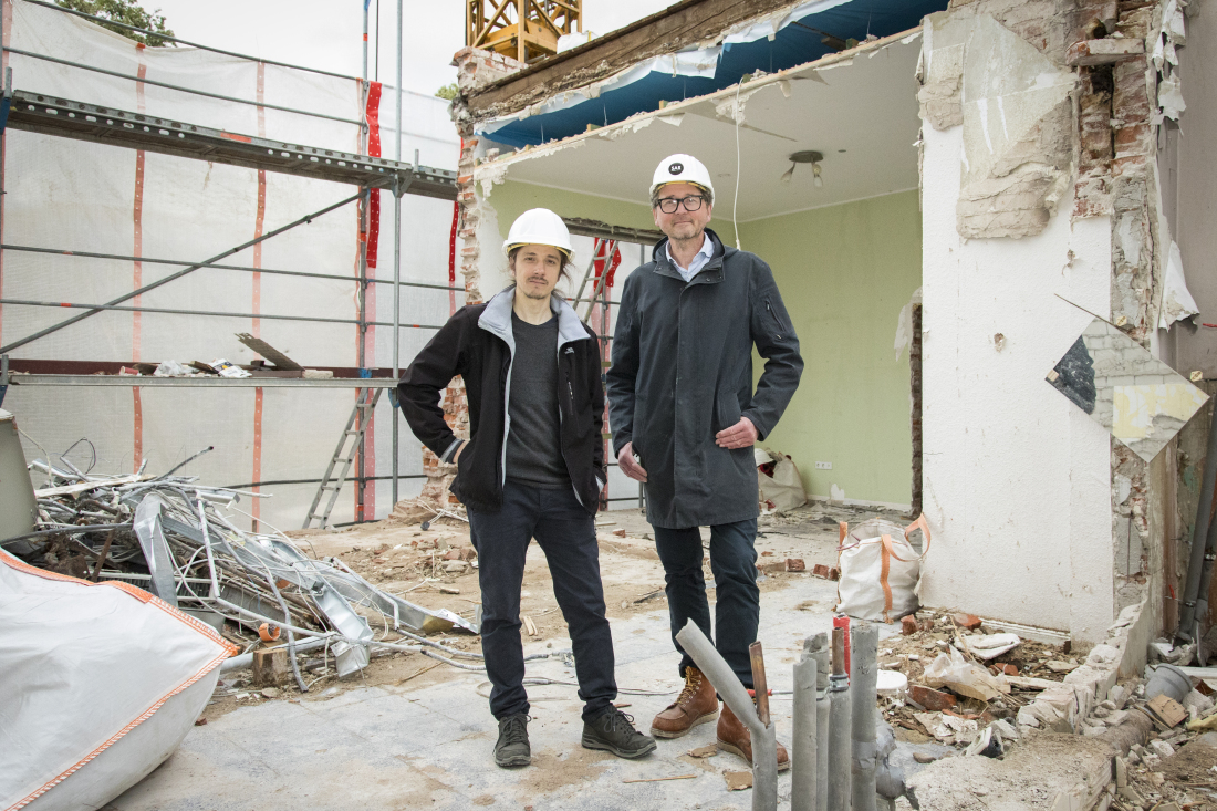 Zwei Männer stehen auf einer Baustelle