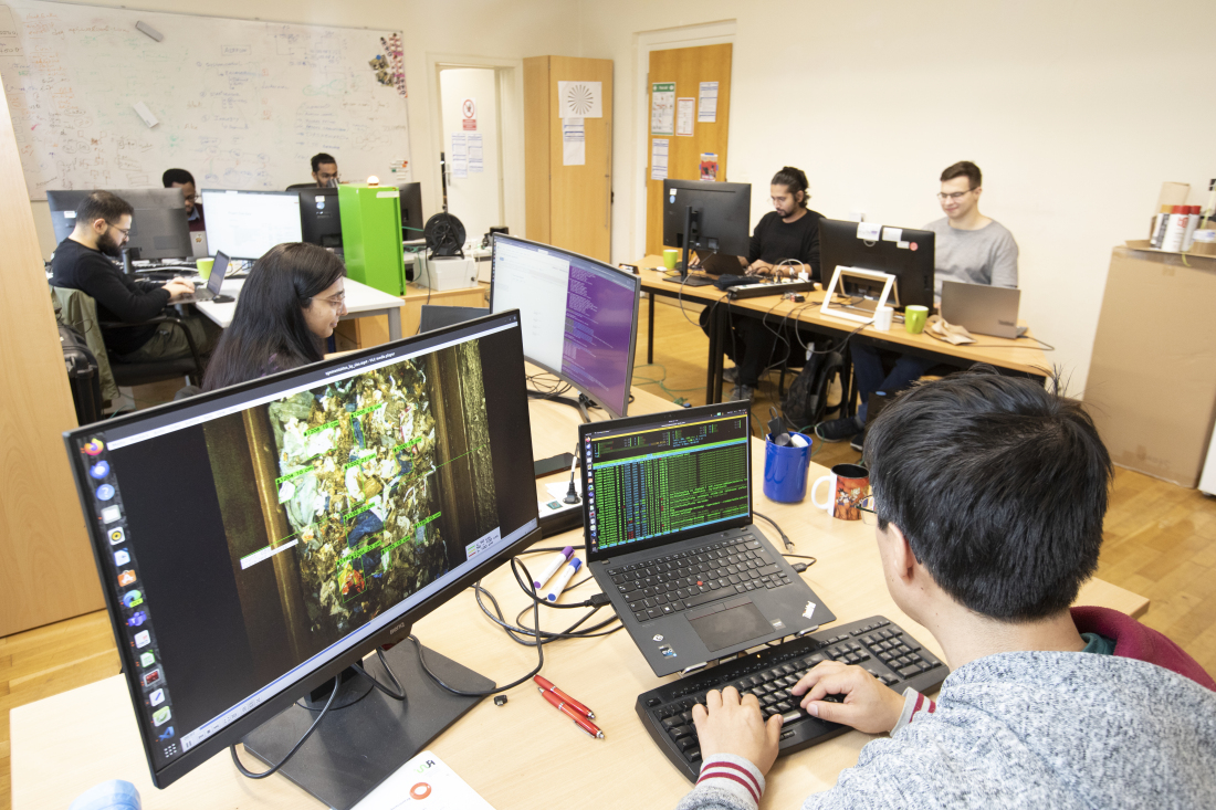 Mitarbeitende arbeiten am PC im Büro