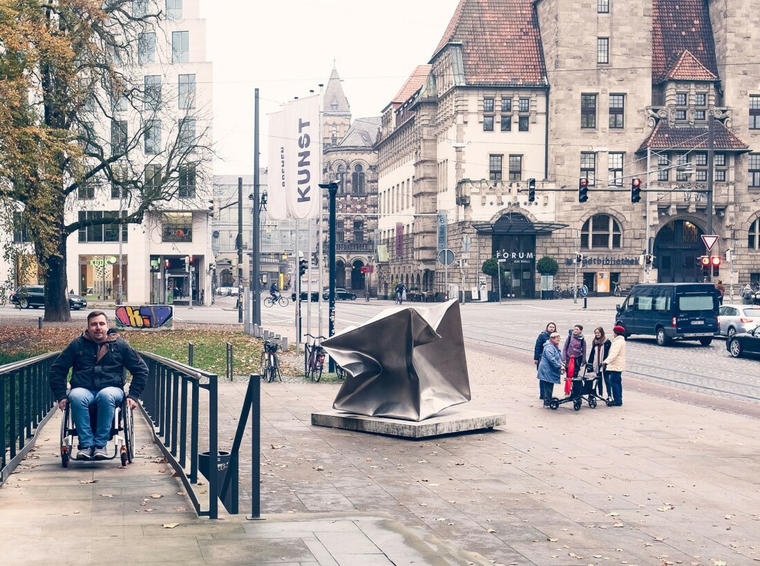 Ein Mann im Rollstuhl fährt die Rampe der Kunsthalle Bremen hoch.