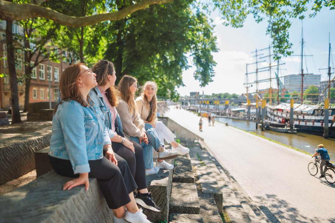 Vier frauen sitzen auf Stufen an der Schlachte Vier frauen sitzen auf Stufen an der Schlachte