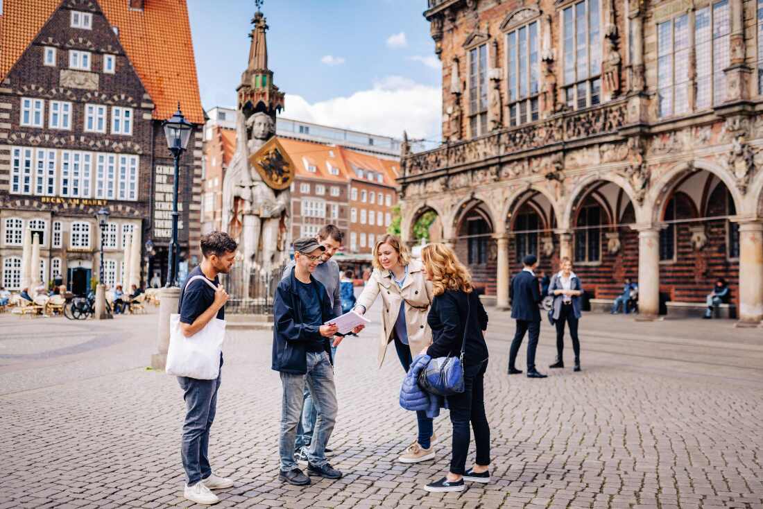 Eine Gruppe Menschen steht vor dem Roland Eine Gruppe Menschen steht vor dem Roland