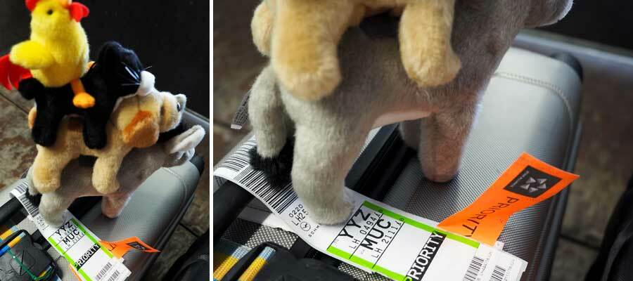 Collage: Die Plüsch-Stadtmusikanten auf einem Koffer, Flughafen-Codes auf Koffer-Schild